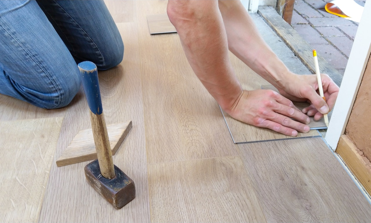 A person taking flooring measurements